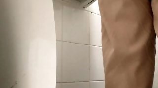 girl peeing over the toilet in a public toilet